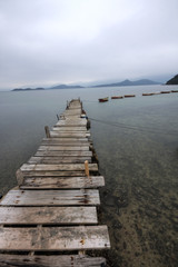 Obraz premium Looking over a desolate peer and a boat.