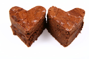 Two heart shaped slices of a brownie on white background