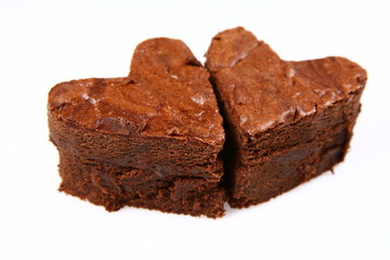 Two heart shaped slices of a brownie on white background
