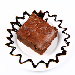 Slice of a brownie on a plate with chocolate custard