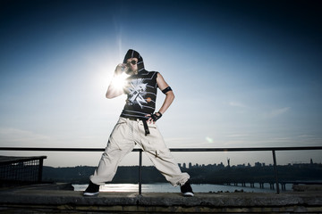 Extreme dance on the brink of a roof against a city landscape