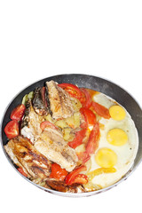 Pan with fried fish, tomatoes and eggs isolated on white