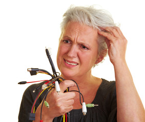 Seniorin schaut Kabel an
