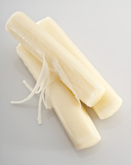 Three pieces of mozzarella string cheese isolated on white