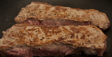 Two Broiled Steaks in a Pan