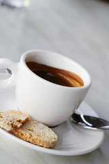 A cup of espresso and some biscuits