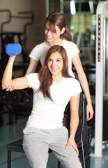 Young woman and instructor in the gym