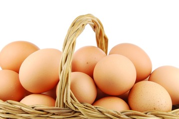 Close-up of eggs in a wicker basket on white
