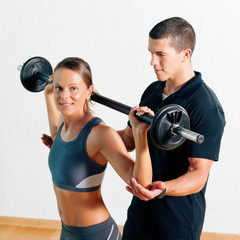 Trainer und Frau im Fitnessstudio