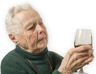 vieille dame observe un verre de vin
