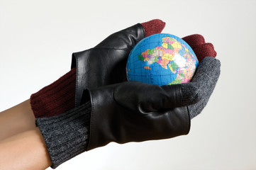 Hands with glove holding a world map