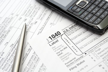 1040 tax return form, cell phone and pen