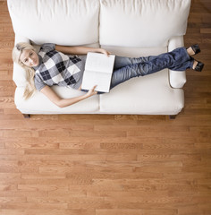 Fototapeta na wymiar Overhead View of Woman With Book on Couch