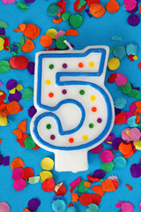 Number five birthday candle on blue background