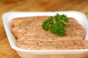raw home made sausages on a styrofoam plate