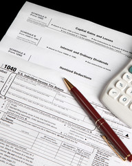 Tax forms on a black background with pen - vertical