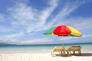 chairs and colorful umbrella on sand beach