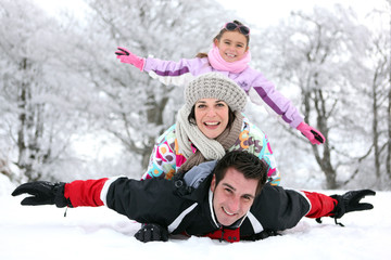 Fototapeta na wymiar Famille s'amusant dans la neige