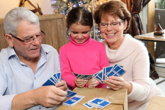 Grand-parents et enfants jouant aux cartes