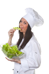 Junge freundliche Köchin mit Salat