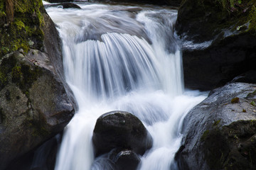 Bach mit fließendem Wasser und Steinen (Felsen)