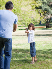 Jolly little boy playing baseball with his father