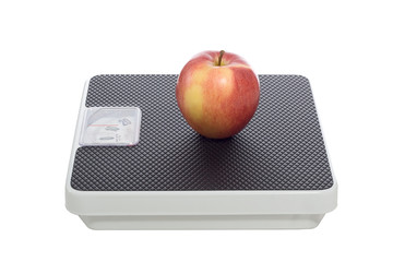 Red apple on a scale, isolated over white