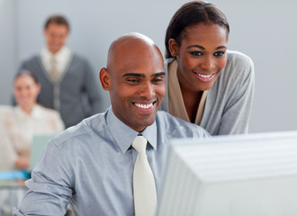 Smiling business partners working at a computer together