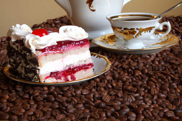 Tasty cake with a cream and a cherry on white ware among coffee
