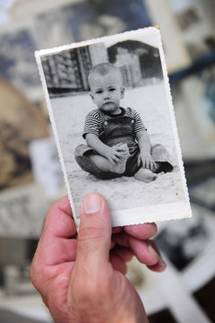 childhood: man holding photo of himself as a boy