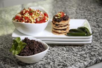Corn salsa, black bean dip served on a stack of toasted bread