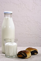 Fresh white milk with browned bun on the table