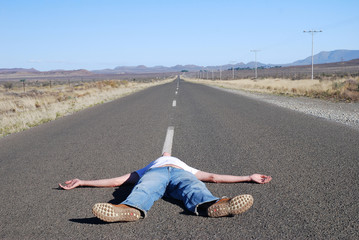 Man lying in the road - obrazy, fototapety, plakaty