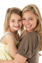 Studio Portrait Of Mother Hugging Young Daughter