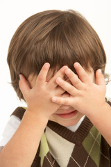 Fototapeta premium Studio Portrait Of Young Boy Covering Eyes