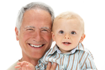 Studio Portrait Of Grandfather Holding Grandson