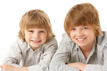 Two Young Boys Lying On Stomach In Studio