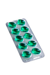 Green tablets in silver package isolated over white background.