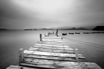 Foto op Aluminium Kijkend over een pier en boten, zwart en wit © leungchopan