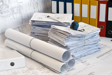 Heap of design and project drawings in yellow folder.