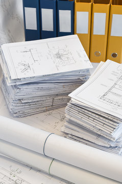 Heaps of design and project drawings and yellow folder.