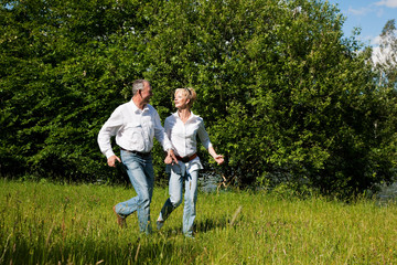 Älteres Paar läuft über eine Wiese