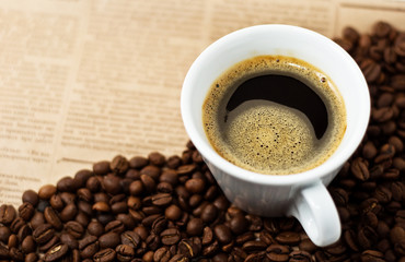 Cup and Coffee Beans on newspaper backgroun