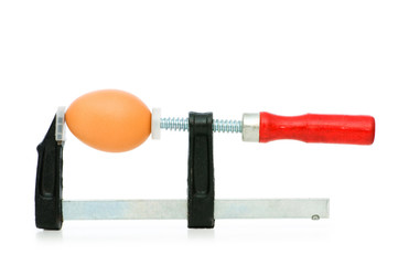 Strength concept with egg and clamp on white