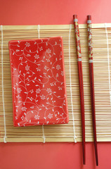 A closeup of a japanese dinner-set: plates & sticks,