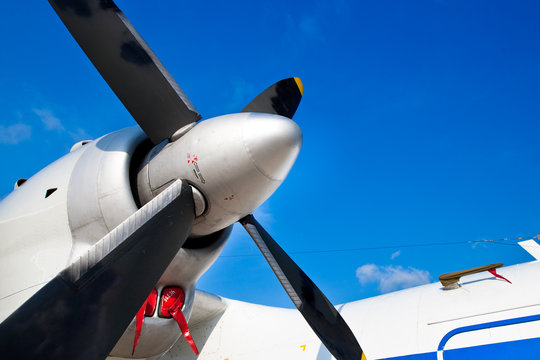 Black Wings Of An Airplane Motor In Blue Sky