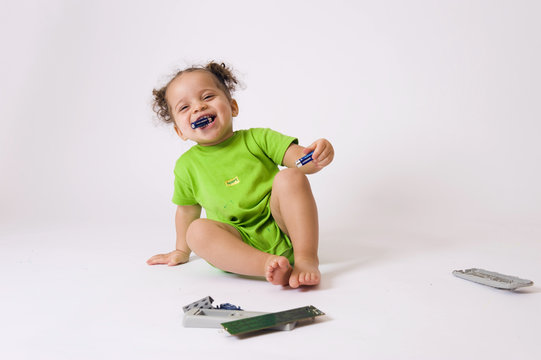 B&eacute;b&eacute; jouant avec la t&eacute;l&eacute;commande de la t&eacute;l&eacute;vision