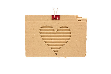heart on a torn piece of cardboard with a metal clip for paper