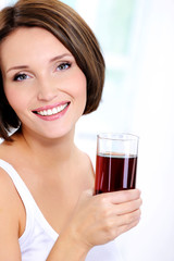 Happy  beautiful female holding glass of a  fresh juice