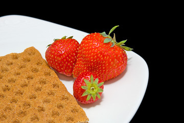 White plate with strawberry and cracker